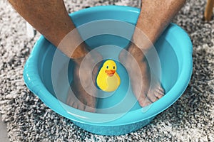 Man soaking his feet in a basin