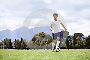 Man, soccer player and dribble with ball on field for moving, speed or skills in low angle at club on training ground