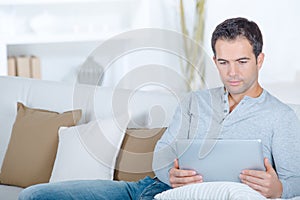 Man on sofa using tablet