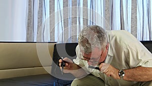 Man soldering a board with a soldering iron, he has in his hands a large magnifying glass