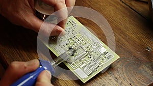 A man solders a print circuit board.