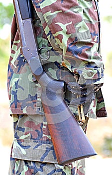 A man in soldier suit with rifle and bullets