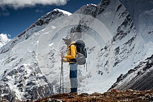 Man solo hiker exploring high altitude mountains. Tourist with mountain clothes walking across track