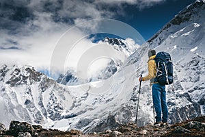 Man solo hiker exploring high altitude mountains. Tourist with mountain clothes walking across track