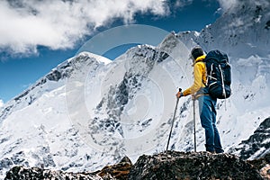 Man solo hiker exploring high altitude mountains. Tourist with mountain clothes walking across track