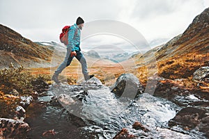 Man solo traveling backpacker hiking in scandinavian mountains photo