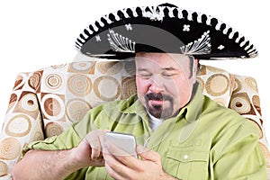 Man in sombrero texting on mobile