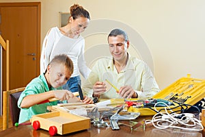 Man with son doing something with the working tools