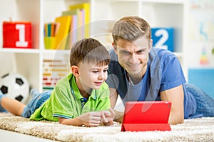 Man and son kid playing with tablet computer