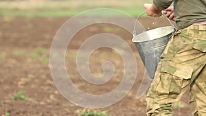 Man sows a field with grain by hand