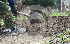 Man with spade in dirt, farmer working