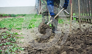 Man with spade in dirt, farmer working