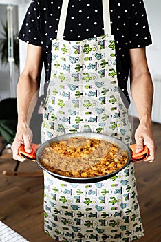 Man with a spanish chicken paella photo