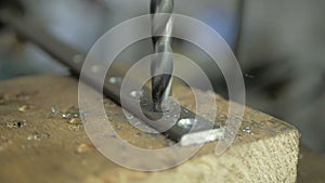 A man specializes a driller drilling holes on a drilling machine in a metal workpiece