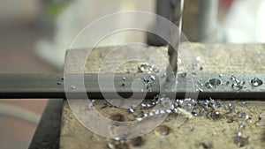 A man specializes a driller drilling holes on a drilling machine in a metal workpiece