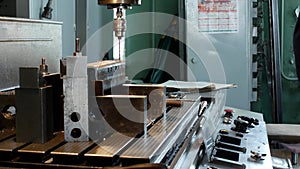 A man specializes a driller drilling holes on a drilling machine in a metal workpiece, a small business, private