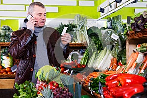 Man specifying shopping list in store