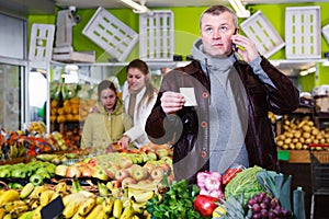 Man specifying shopping list in store