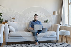 Man spend day off at home using modern laptop