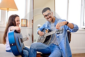 Man spending special moment with little daughter, singing and playing guitar