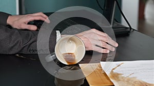 Man Spilling Coffee on his Desk while Working