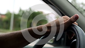 Man spinning steering wheel with one hand, car driving lessons, instructor