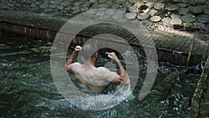 Man splashes in water. Splashing happily lake at resort. Pool rejoicing spray