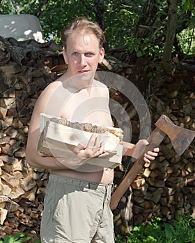 The man with a splitting axe prepares firewood to heat the house