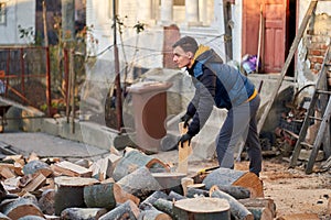 Man splitting wood with axe and maul