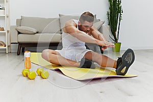 Man sport does muscle and body stretching, pumped up man fitness trainer does sports at home, the concept of health and