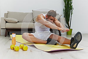 Man sport does muscle and body stretching, pumped up man fitness trainer does sports at home, the concept of health and