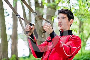 Man at sport training with sling trainer