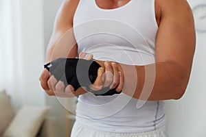 Man sports arm pain muscle and ligament sprain from working out at home, pumped up man fitness trainer works out at home