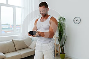 Man sports arm pain muscle and ligament sprain from working out at home, pumped up man fitness trainer works out at home