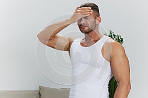 Man sports headache, migraine and dizziness from working out at home, pumped up man fitness trainer works out at home