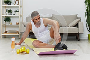 Man sports heart pain, stroke from working out at home, pumped up man fitness trainer works out at home, concept of