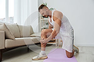 Man sports pain in the side and leg during a workout at home, pumped up man sports, the concept of health without