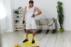 Man sports stomach and side pain, muscle growth exercises, pumped up man fitness trainer works out at home, the concept