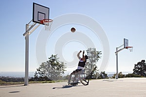 Man in sports wheelchair throwing basketball