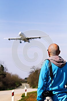 Man is looking at the plane which is landing