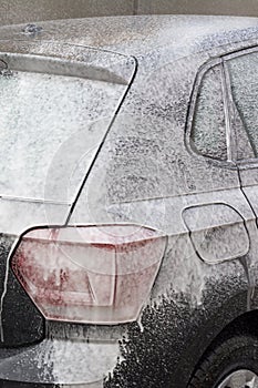 Man Spraying Active Foam During Car Washing