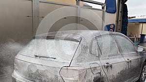 Man Spraying Active Foam During Car Washing