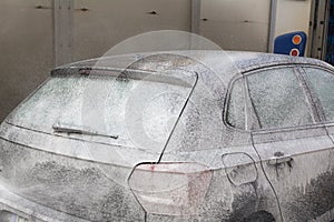 Man Spraying Active Foam During Car Washing