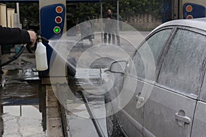 Man Spraying Active Foam During Car Washing