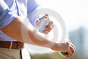 Man Spraying Anti Insect Deet Spray On His Arm