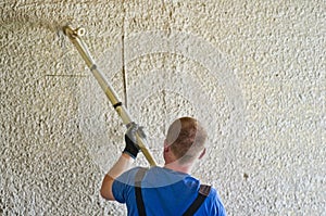 Man spraying concrete stucco to wall