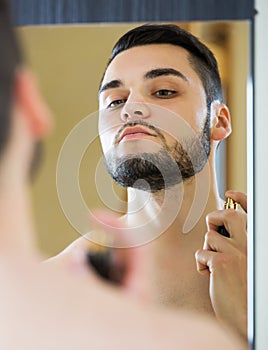 Man spraying fragrance perfume