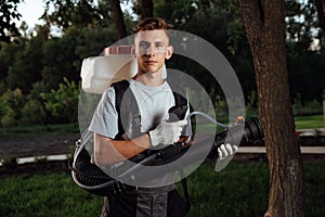 Man spraying insect repellent. Gardener with insect sprayer