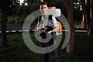 Man spraying insect repellent. Gardener with insect sprayer