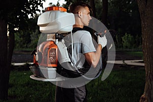 Man spraying insect repellent. Gardener with insect sprayer